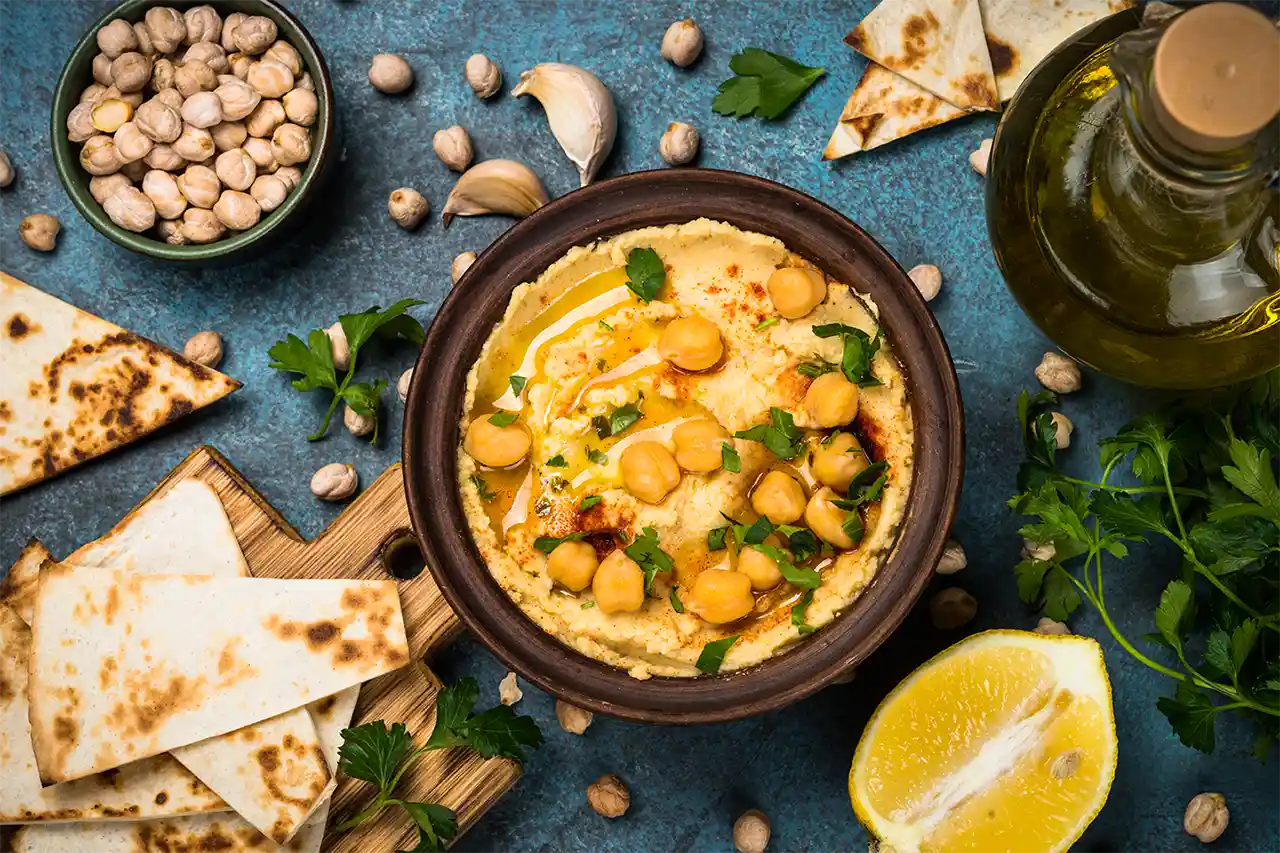 Aperitive festive cu hummus delicios, servite cu legume proaspete și pâine crocantă